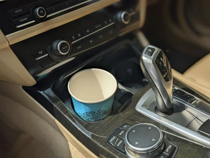 a cup and cell phone holder in the middle of a car dashboard