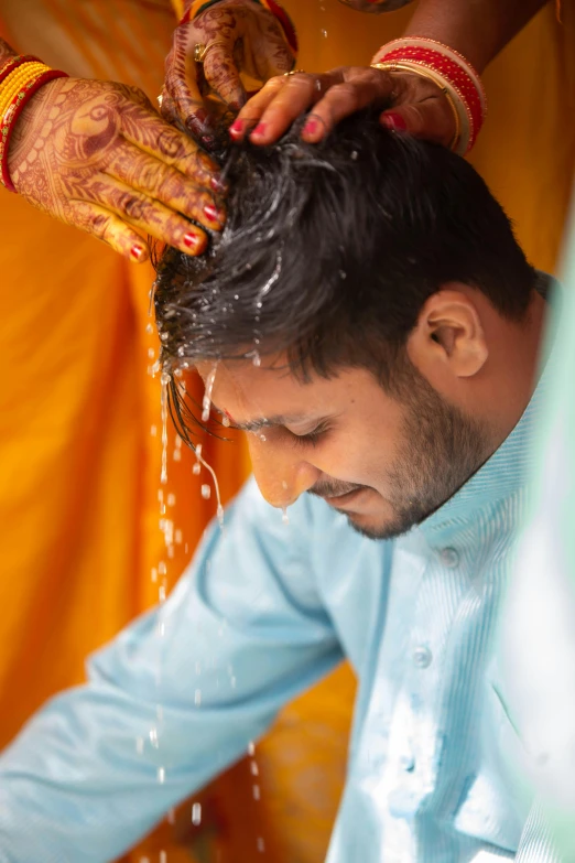 a man getting his hair washed by a woman