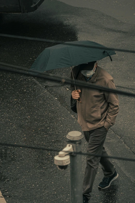 a man standing next to a fire hydrant holding an umbrella