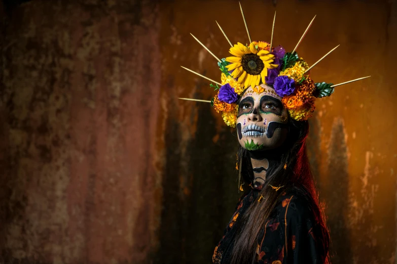 a woman wearing a skeleton makeup is standing with flowers in her hair