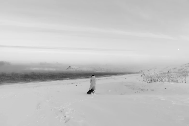 a man walks down a snowy hill on a snowboard