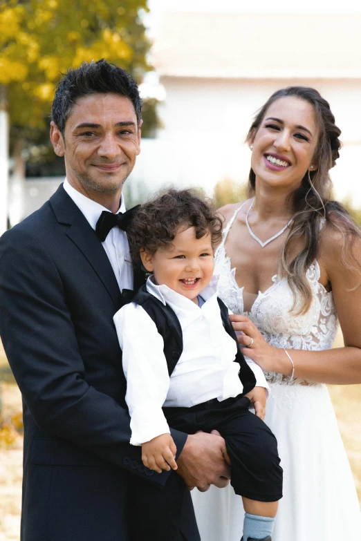 a couple and their little boy posing for the camera