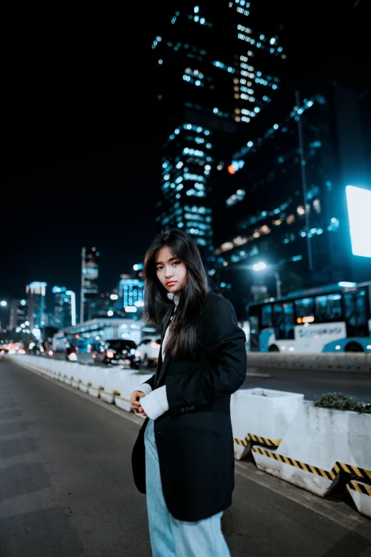 young lady standing outside in front of city lights