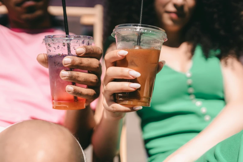 a person holding two cups full of liquid