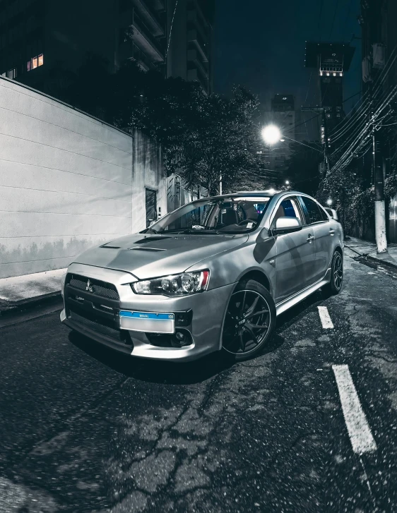 a silver car is parked on a dark street