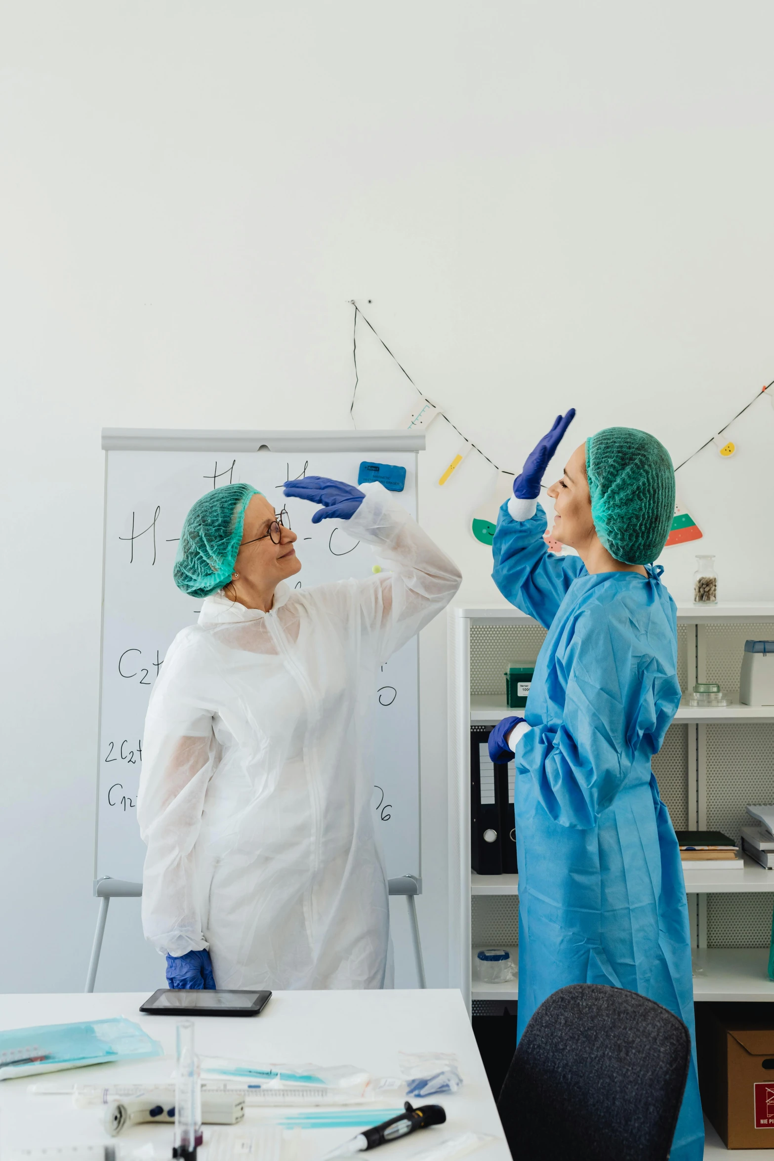 a couple of people in scrubs and green gloves