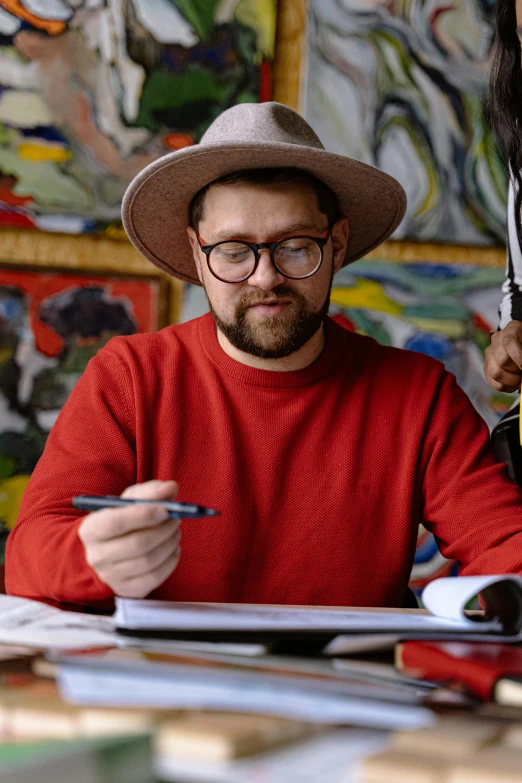 man in a hat is sitting in front of a table