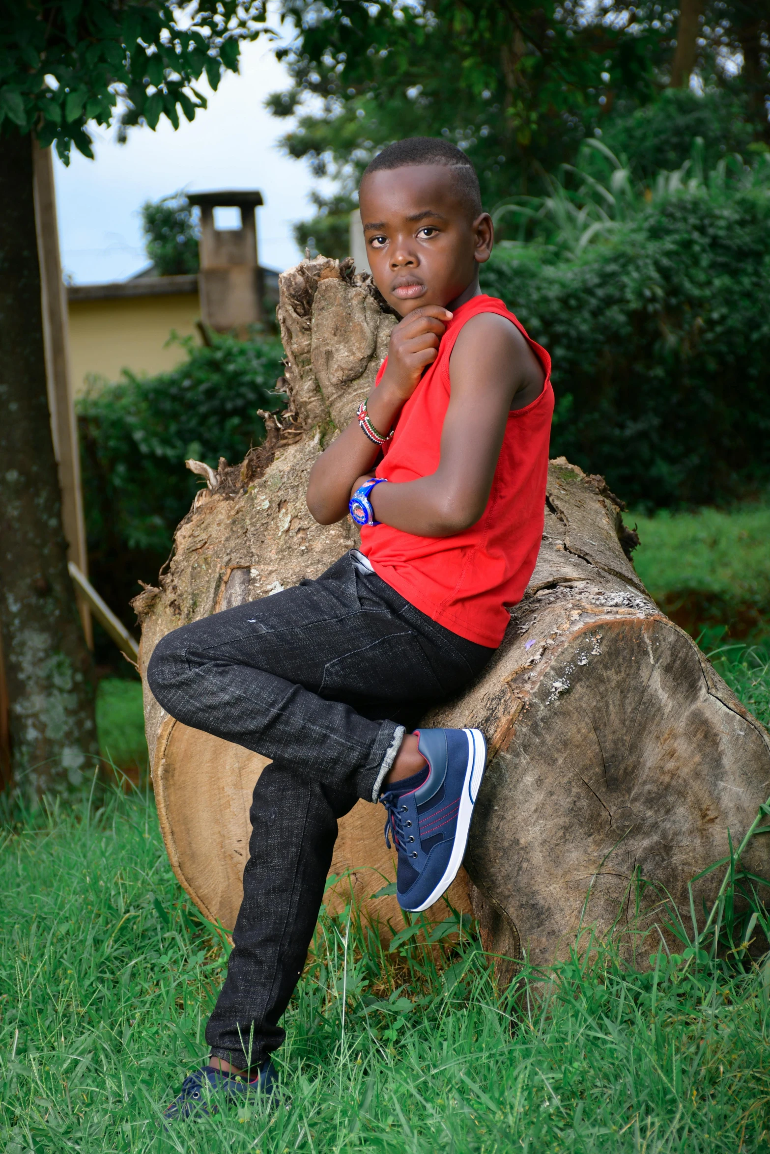 a black boy sits on a tree stump