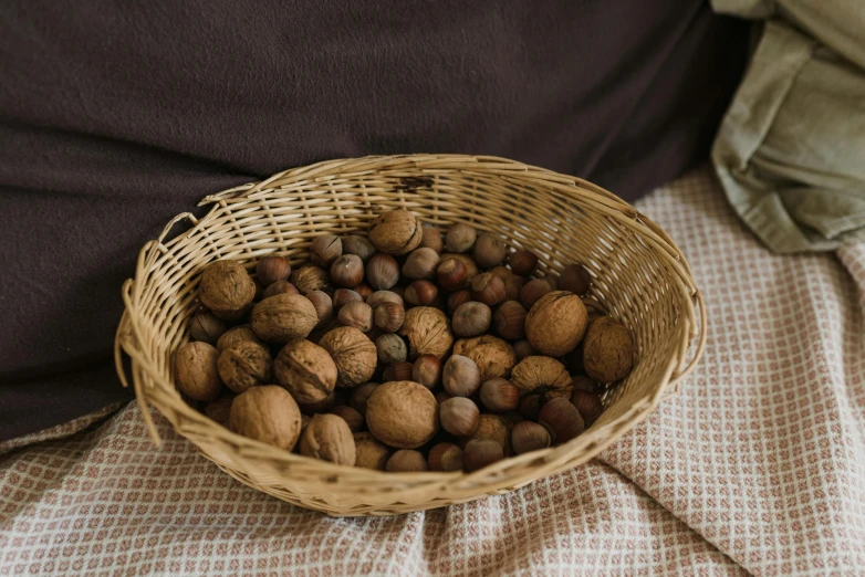 a wicker basket holding nut shells next to the bed