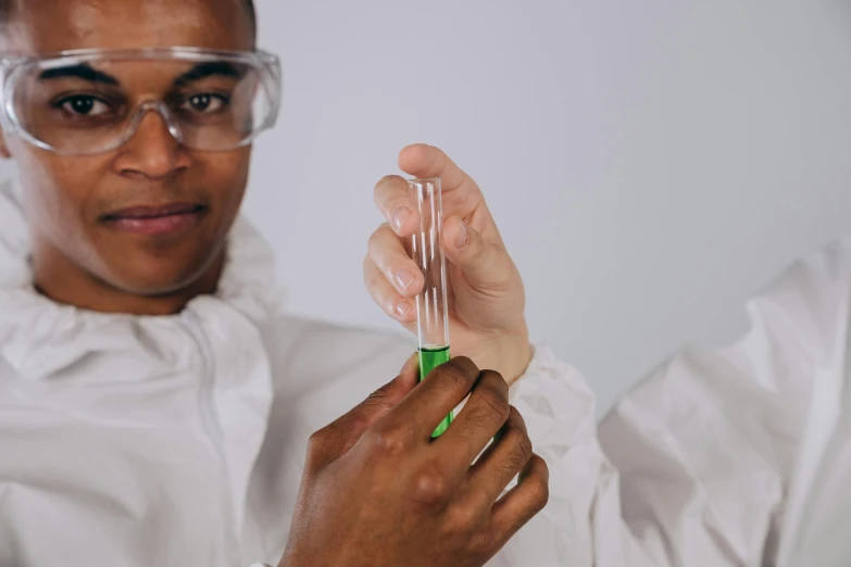 a man in a lab coat and glasses is holding soing green