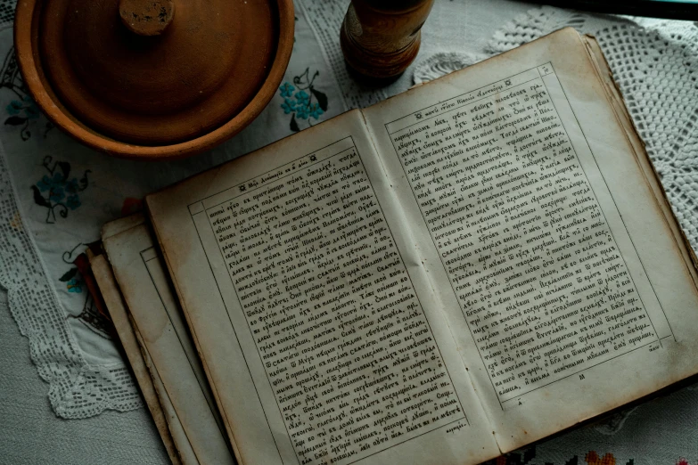 an open book that is sitting on a table with a small bowl