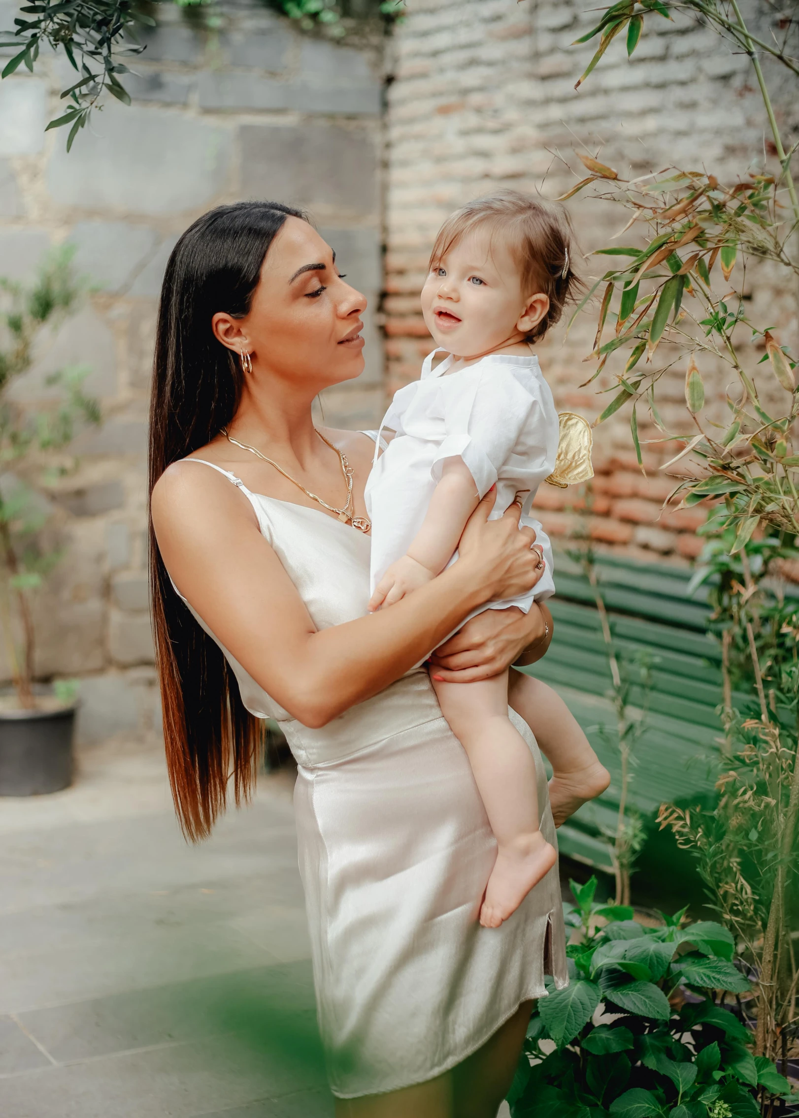 the woman holding the baby smiles happily