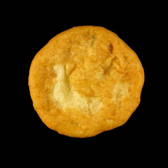 a close up s of a baked cookie on a black background