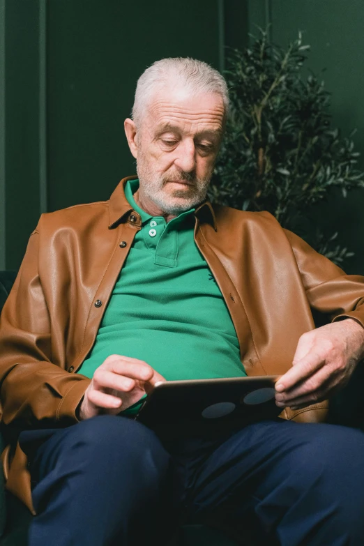 an older man looking at soing while seated