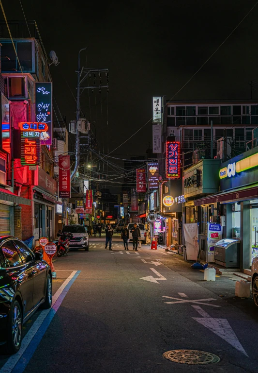 city street lit up by neon signs at night