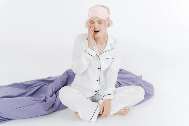 a woman dressed in white pajamas sitting down