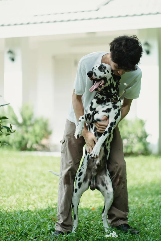there is a man playing with a dalmatian