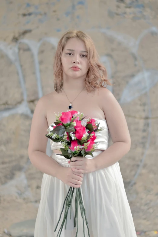 the woman in white dress is holding a bunch of flowers