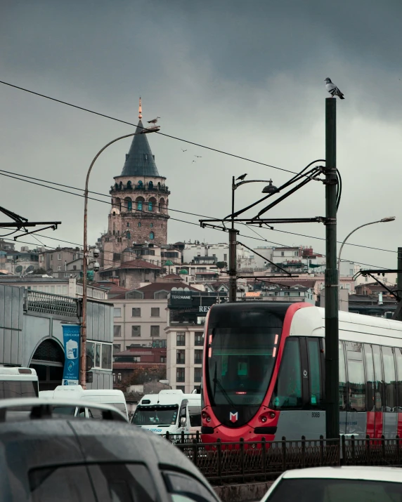 a red and white train passing under wires