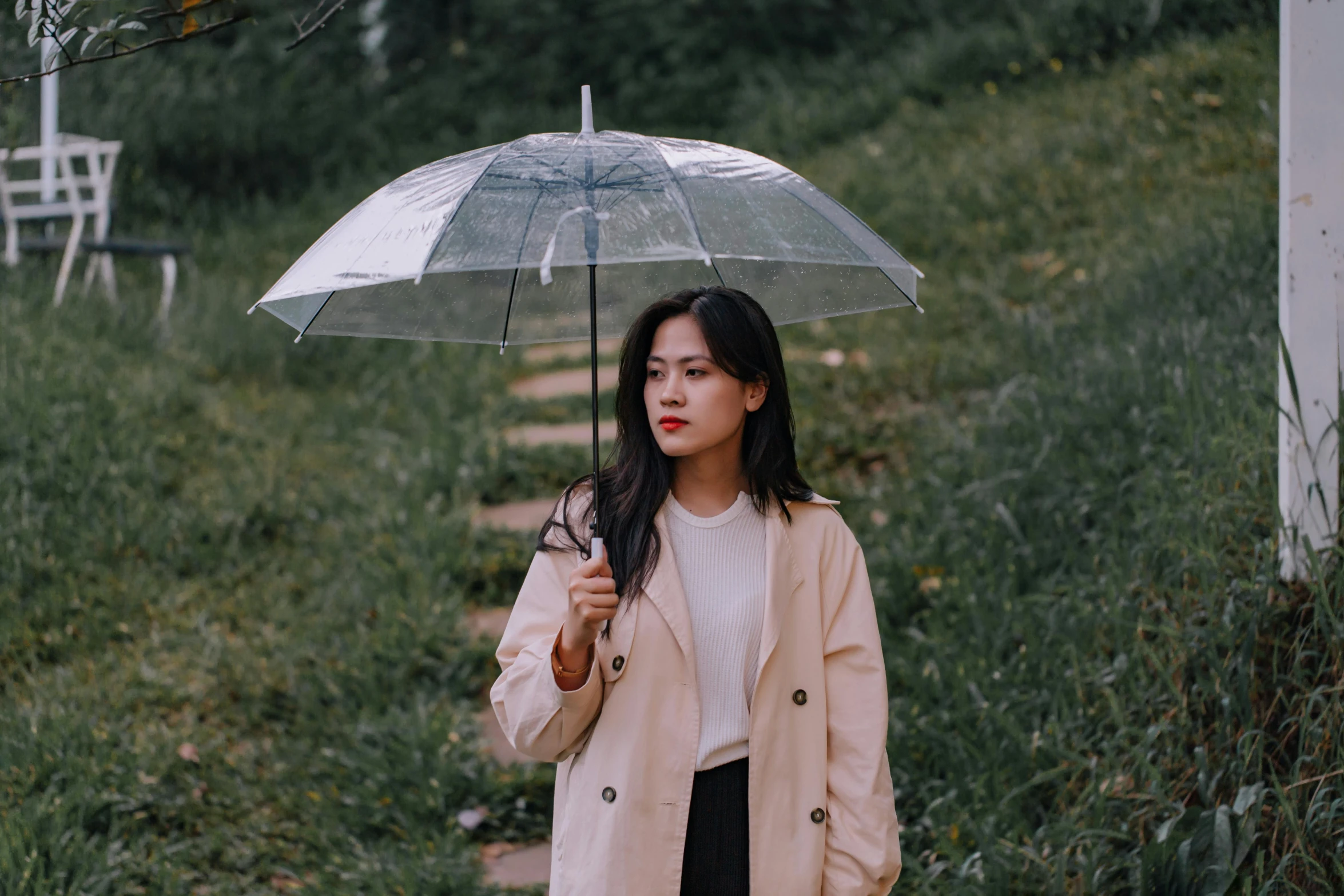 the young lady is standing outside with an umbrella