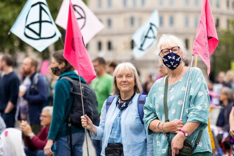 two women are holding flags in protest outside