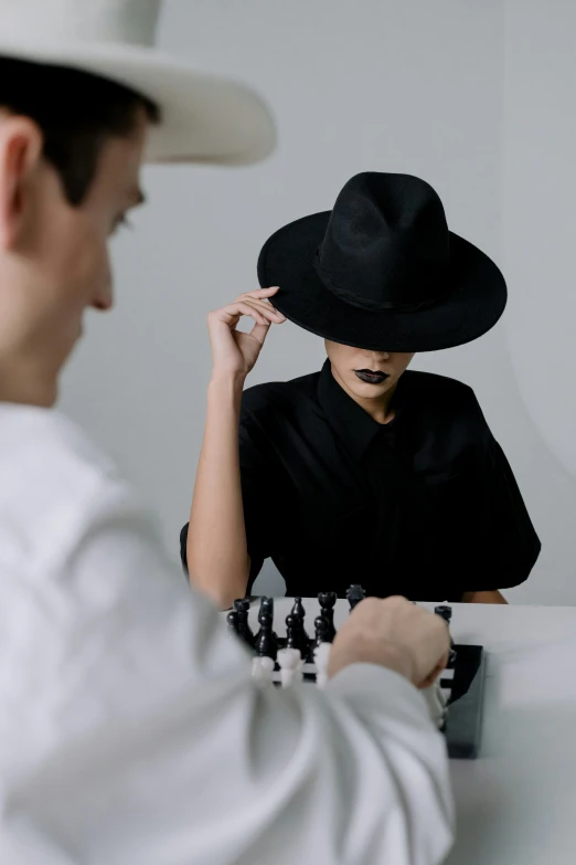 a man wearing a black cowboy hat next to another man