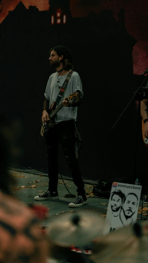 a person is standing and playing guitar on the stage