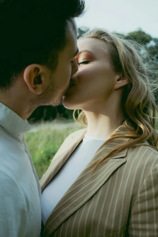 a man and woman standing next to each other and kissing