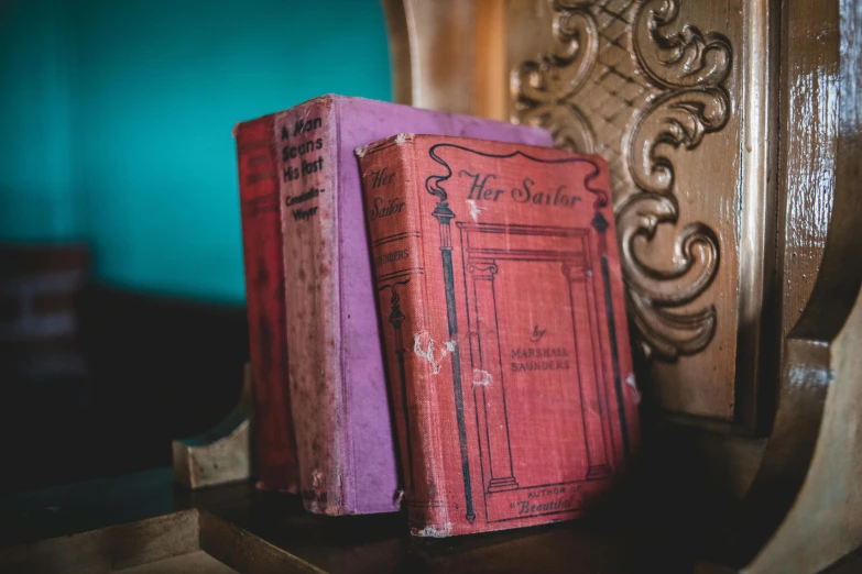 two old red books sitting next to each other on a table