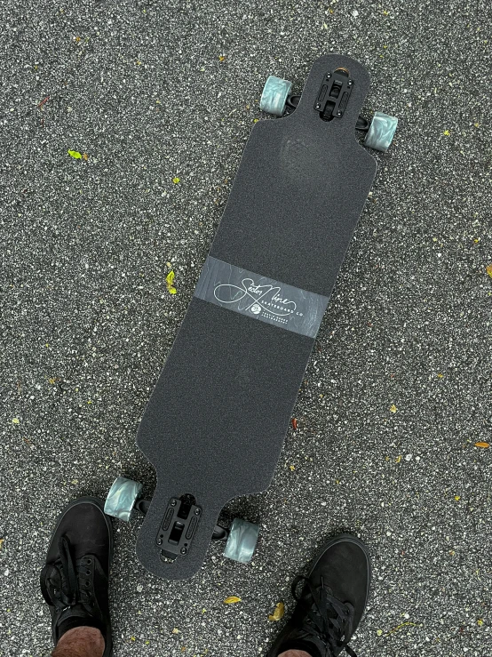 a person wearing a pair of black shoes standing on a skateboard