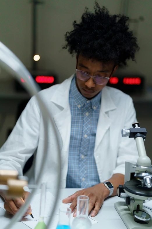 the scientist is examining his microscope at the laboratory