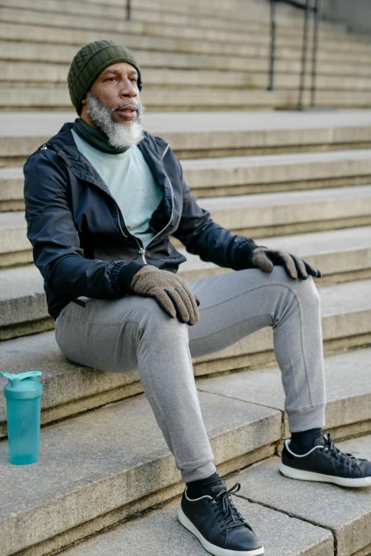 a man sitting on the steps next to a cup