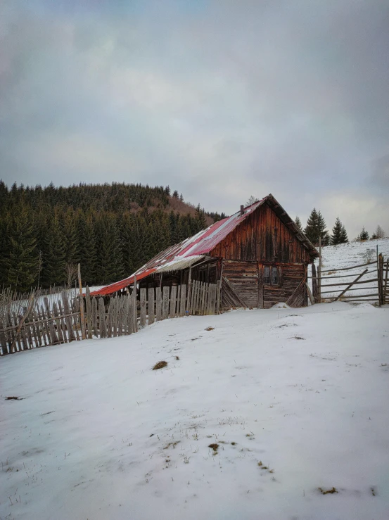 an old farm shed in winter on the side of a road