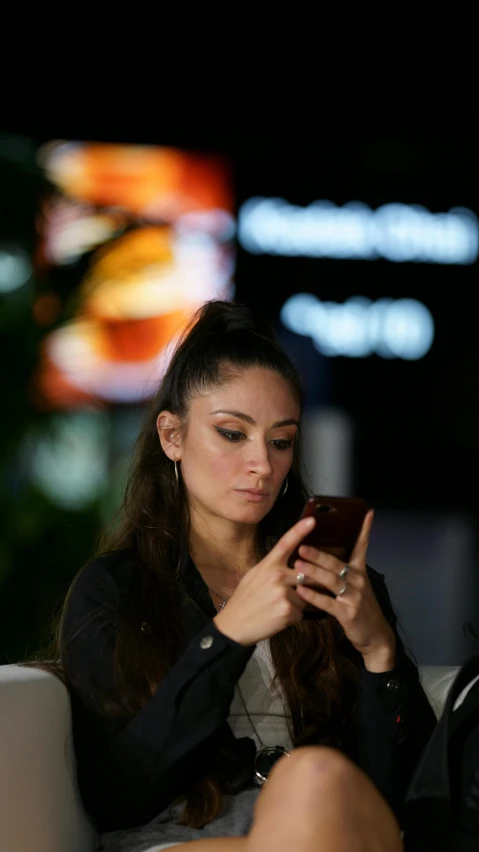 woman sitting on a couch looking at her phone