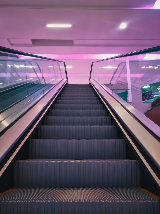 an escalator going down a tunnel like building