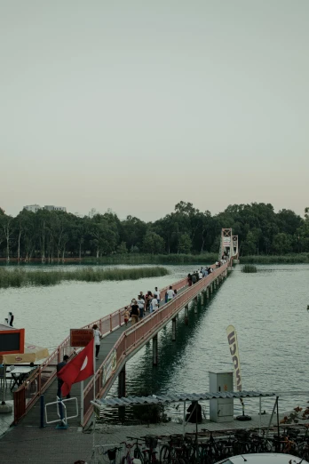 several people standing at the edge of a long wooden pier