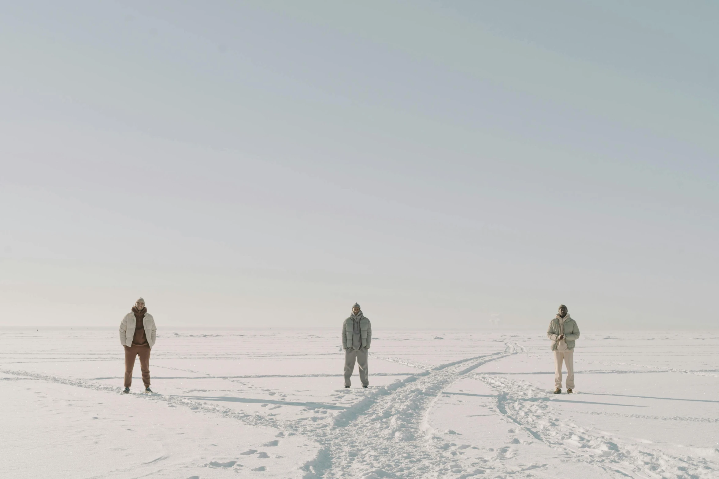 three people on top of a snow covered field