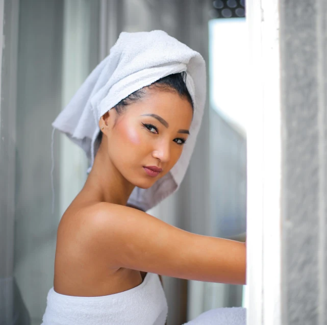 a woman with a towel on her head in a bathroom