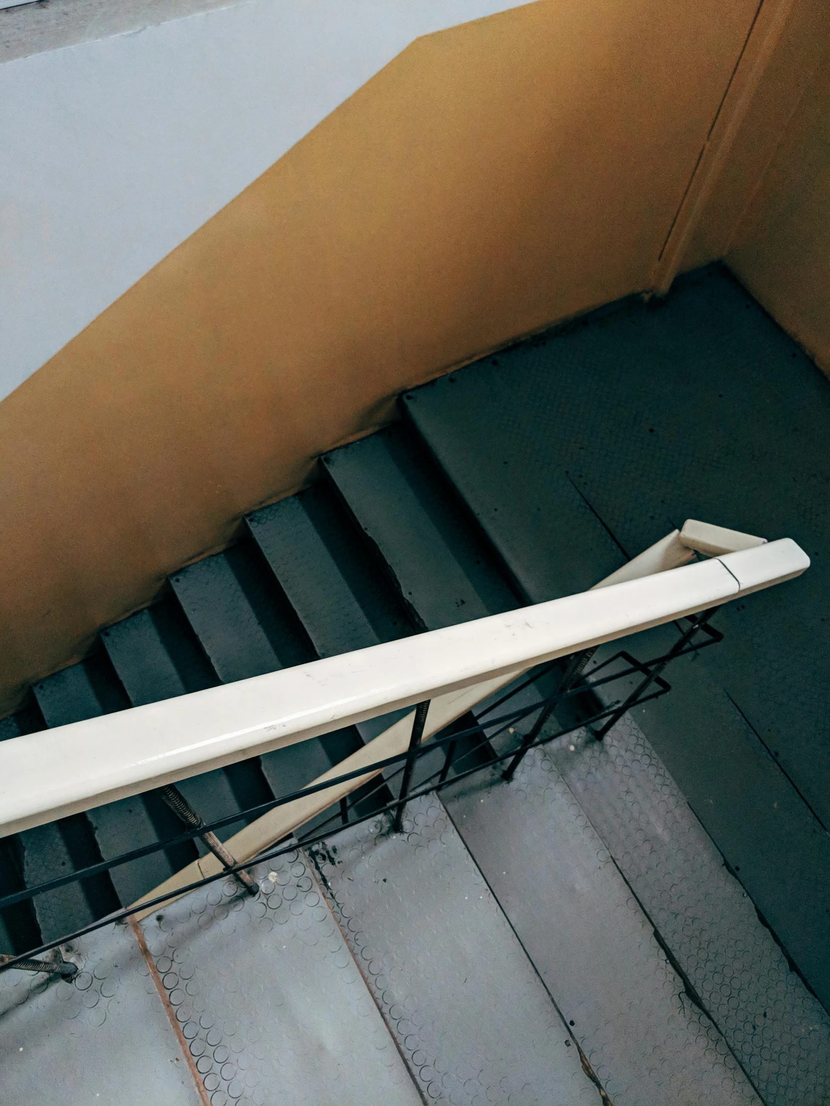 a white surfboard sitting on top of an iron stair railing