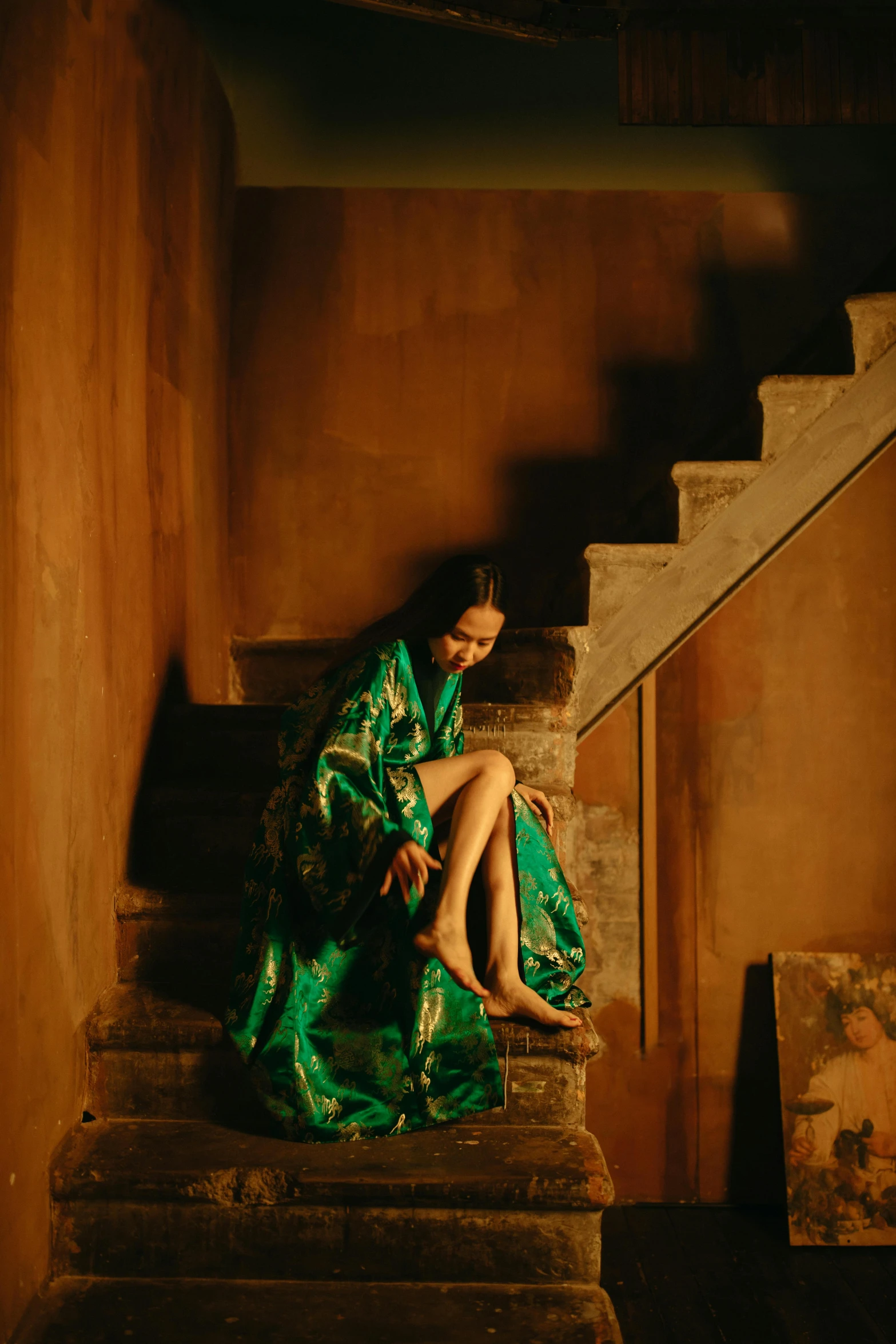 a girl in a green dress sitting on the steps