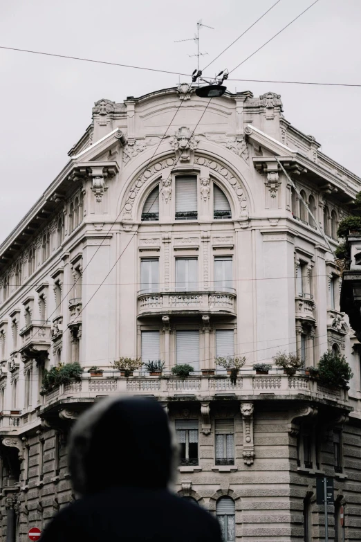 a person in black jacket standing outside of an old building