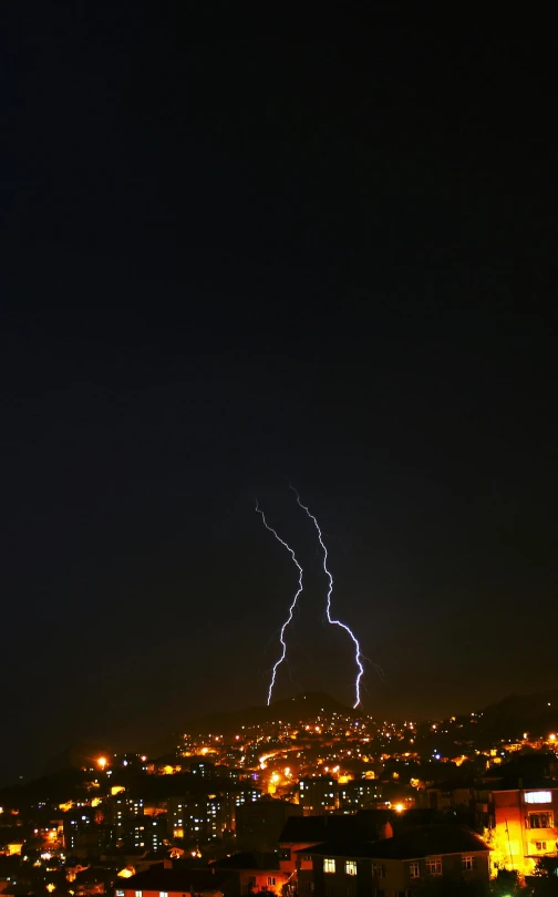 a city at night with many lights and a lightning