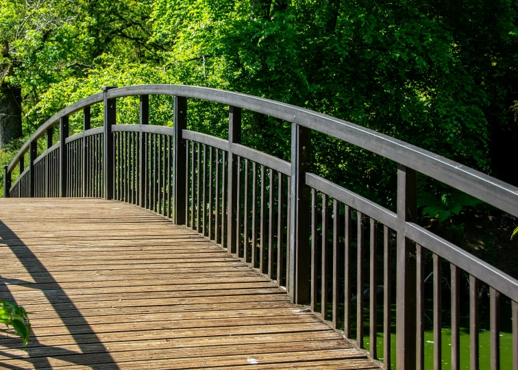 a metal path bridge crosses an area of grass