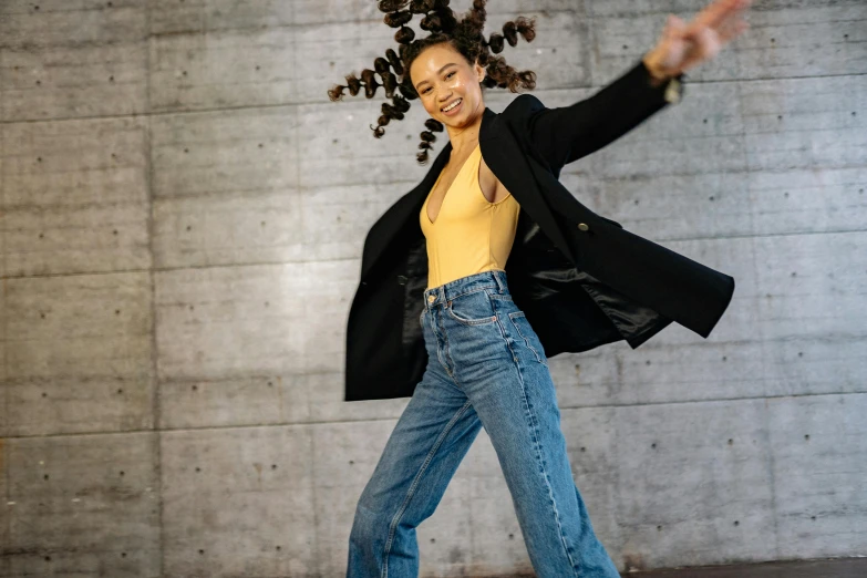 a girl dancing outside, with a long coat on