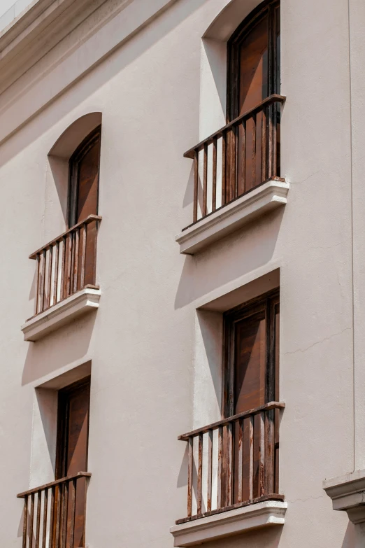 an apartment building with balconies and multiple open windows