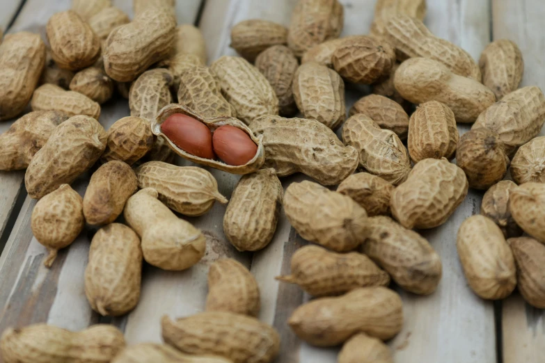 peanuts with one in the middle, sitting on a wooden table