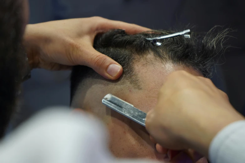 a close up of a person getting a haircut