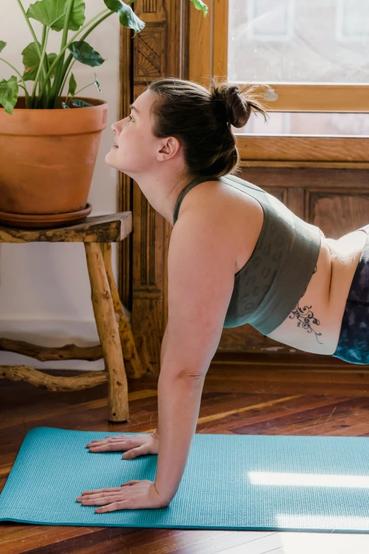 a woman is doing exercises on a blue yoga mat