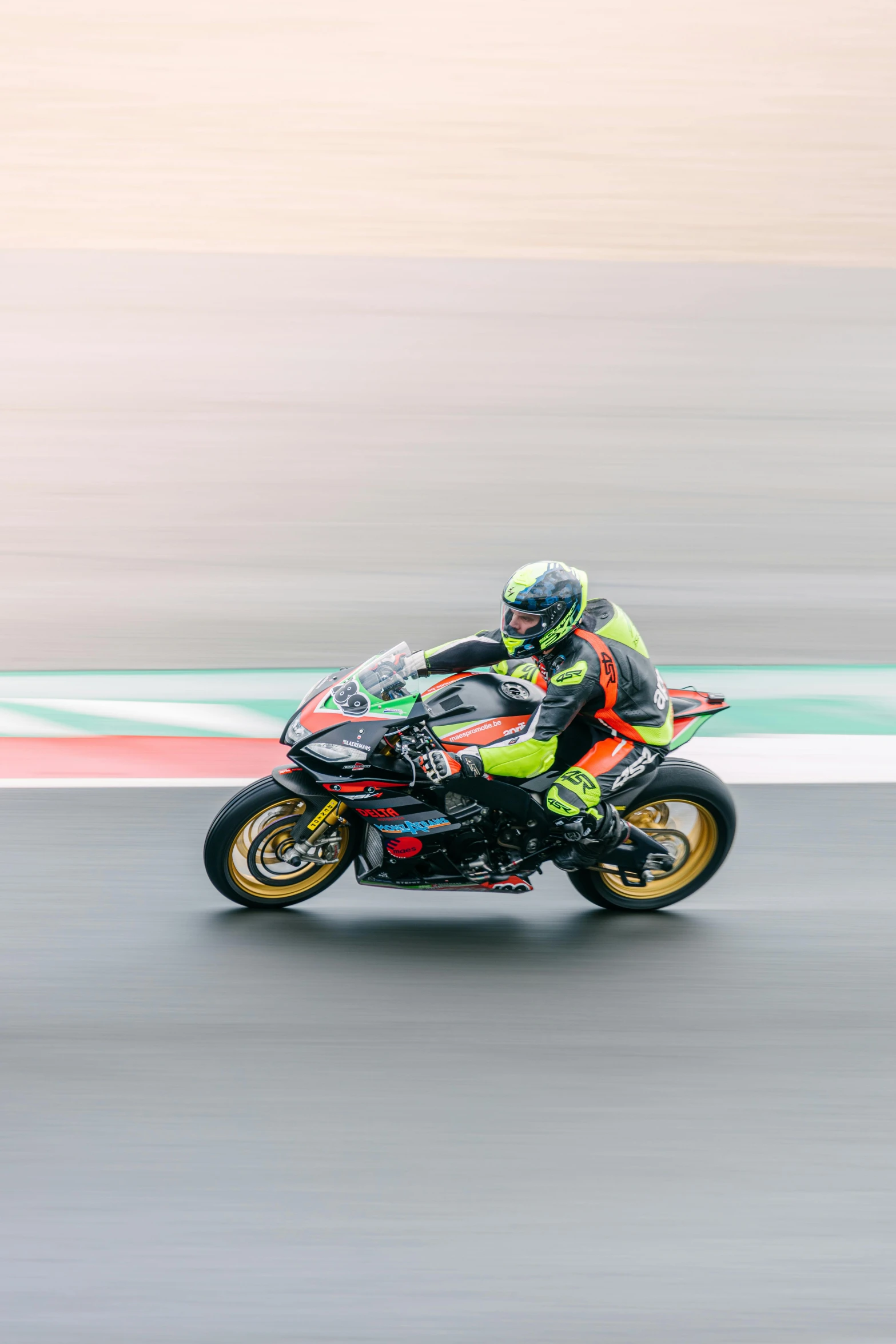 a man riding on the back of a motorcycle down a race track