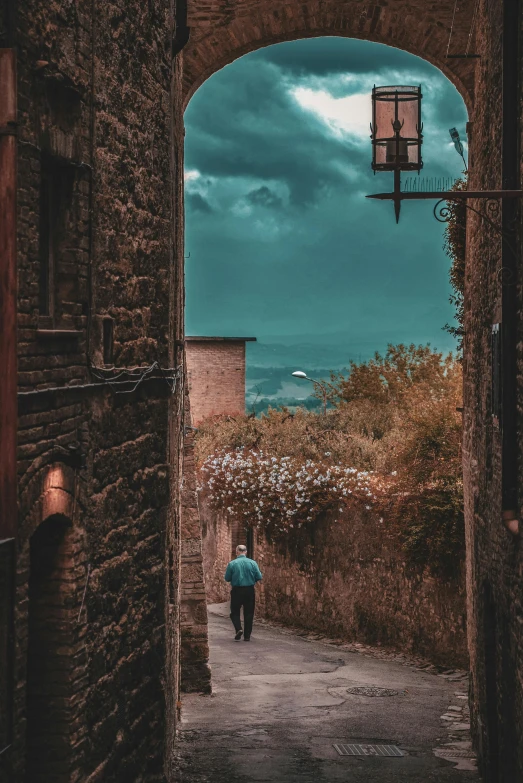 a person standing in an archway way between buildings